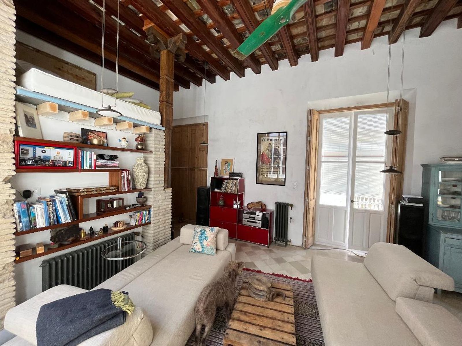 Una pareja de 'chaiselongue' tapizado en lino y un mueble de los años 80, de acero cromado y rojo, protagonizan parte del espacio.