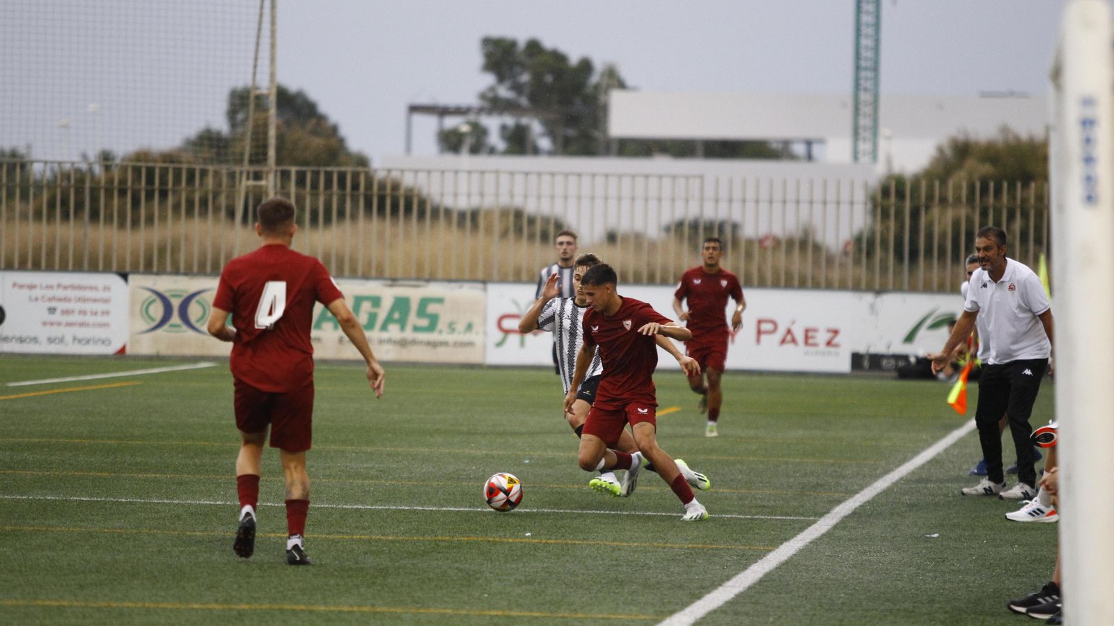 Un jugador sevillista trata de sortear a un jugador de La Cañada ante la atenta mirada de Israel Polo.