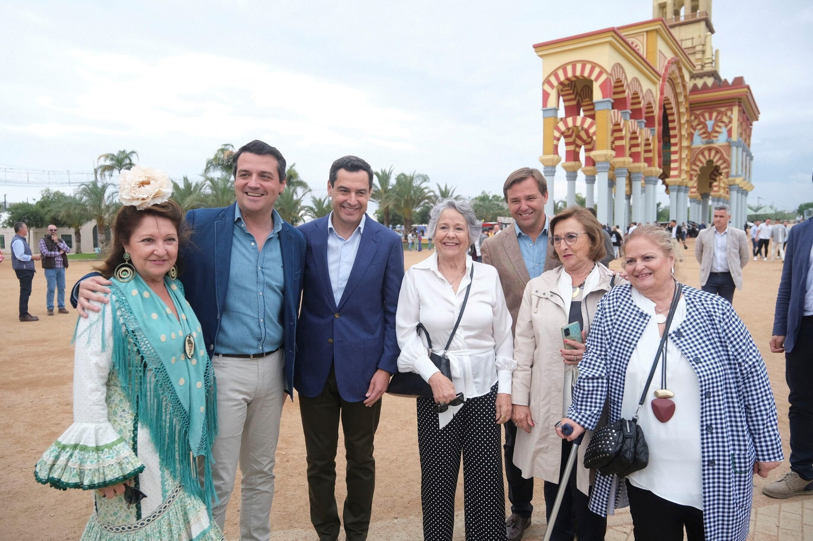 Juanma Moreno, José María Bellido y Antonio Repullo posan con una mujeres en la Feria.
