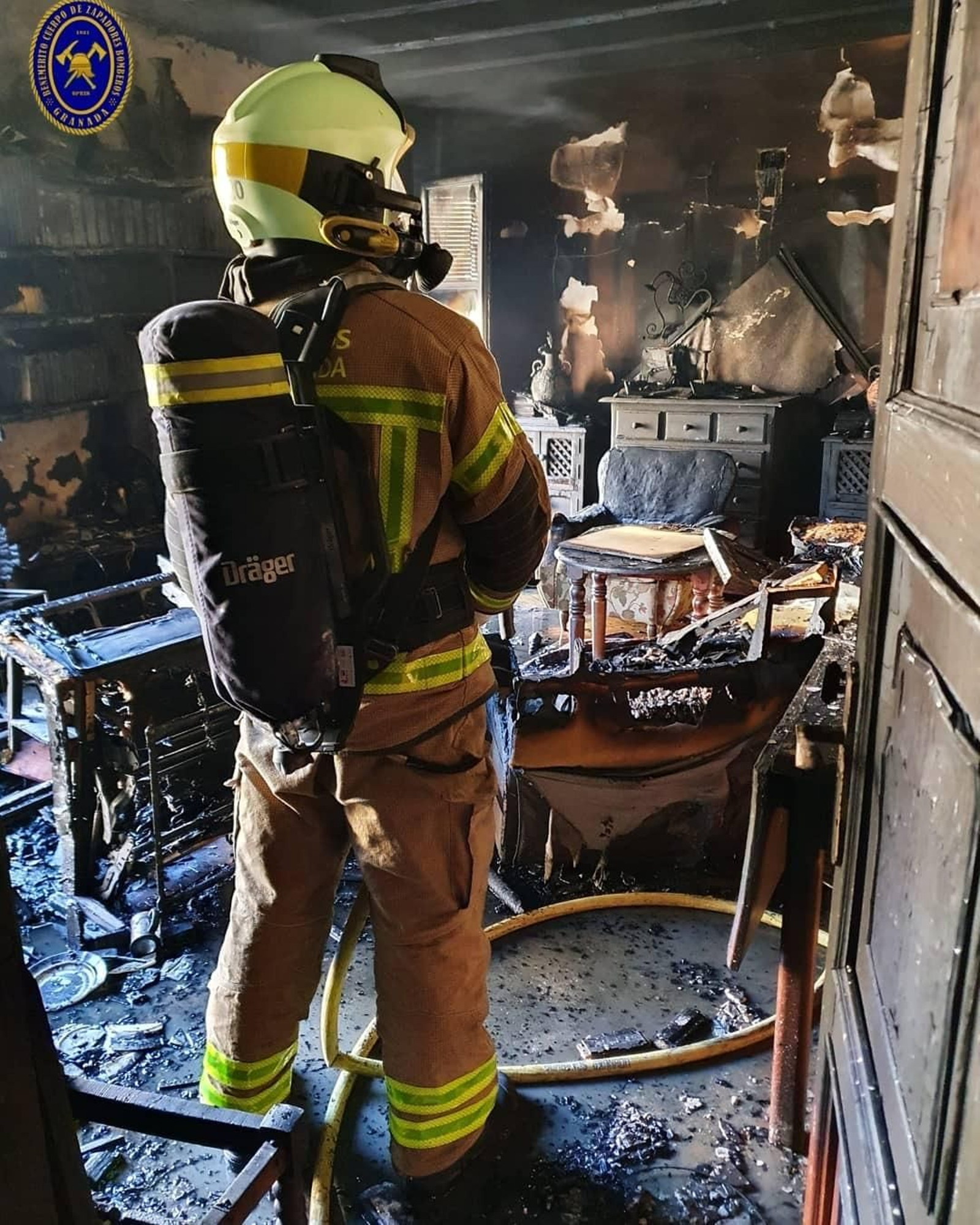 Bombero de Granada interviene en el incendio de una vivienda en un documento de archivo Bombero de Granada interviene en el incendio de una vivienda en un documento de archivo