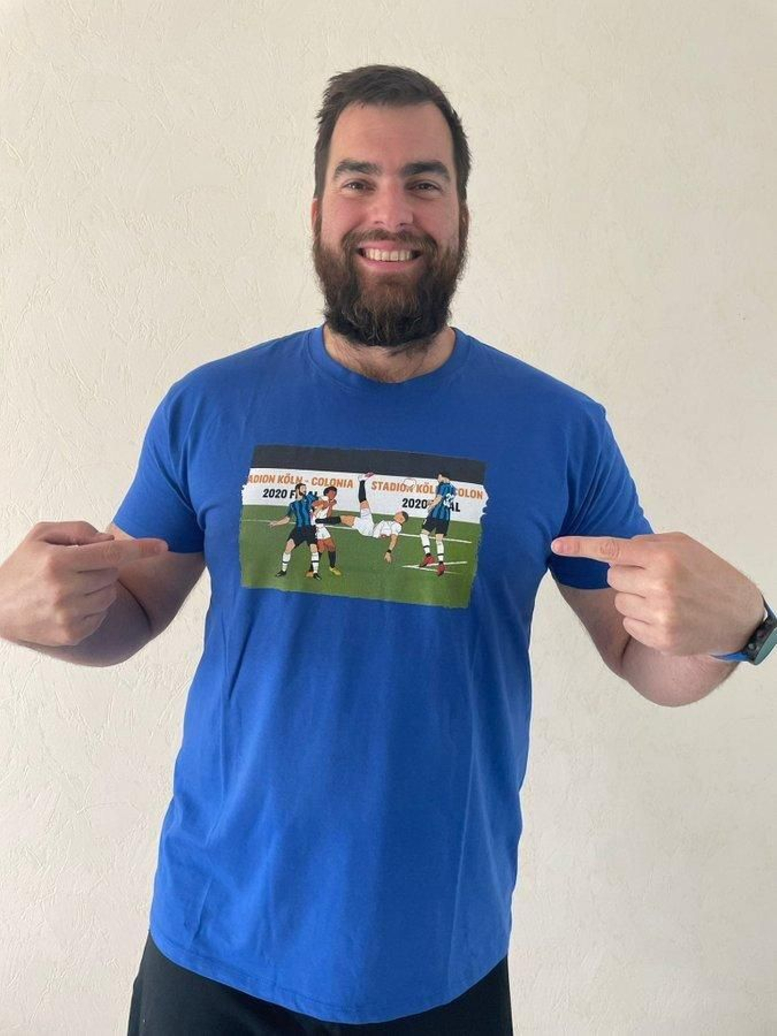 Juan Andreu muestra su camiseta de la final de Colonia con la chilena del sevillista Diego Carlos.