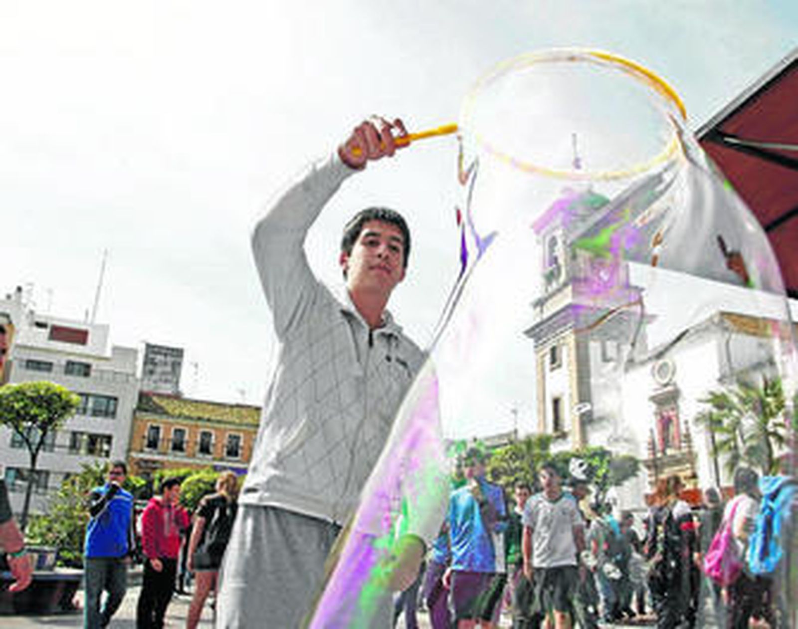 Un joven enseña a hacer pompas de jabón gigantes.