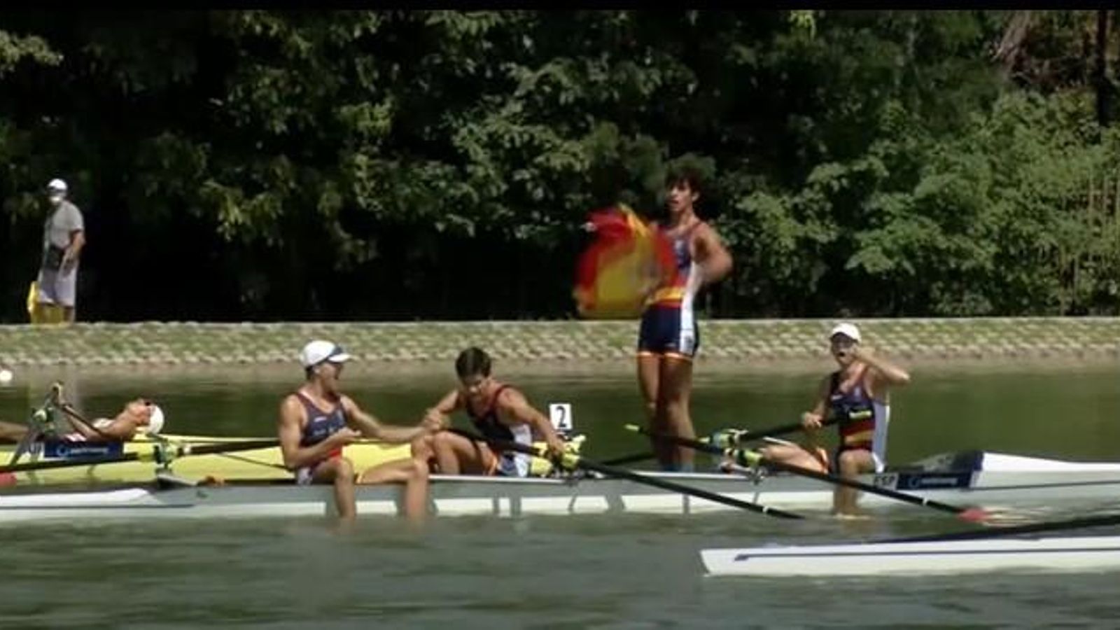 Los integrantes del cuatro sin sacan una bandera de España para celebrar el triunfo.