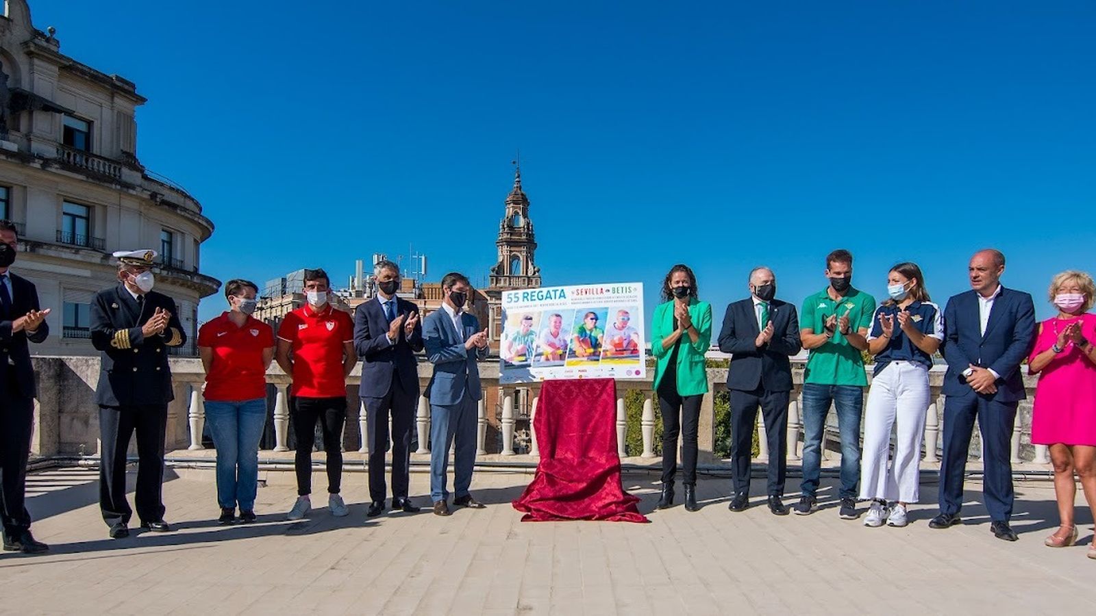 Los asistentes al acto posan junto al cartel.
