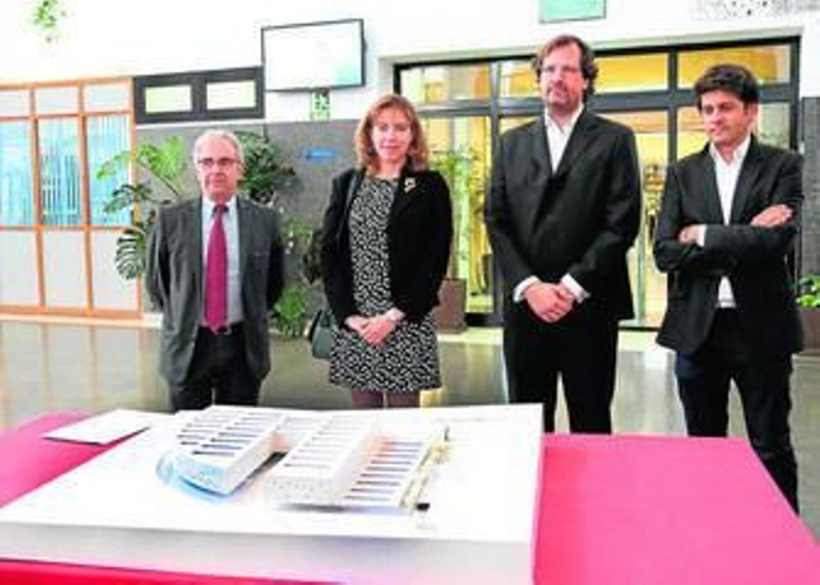 El decano, Julián Almaraz (izda.), y la vicerrectora Raquel Barco, con los arquitectos y la maqueta de la futura facultad.