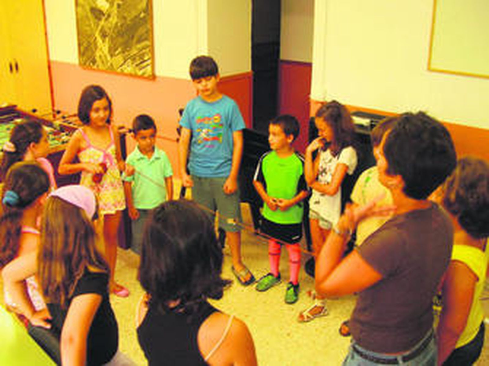 Diversos niños participan en un taller de verano con una monitora en Los Cortijillos que durará todo el verano.
