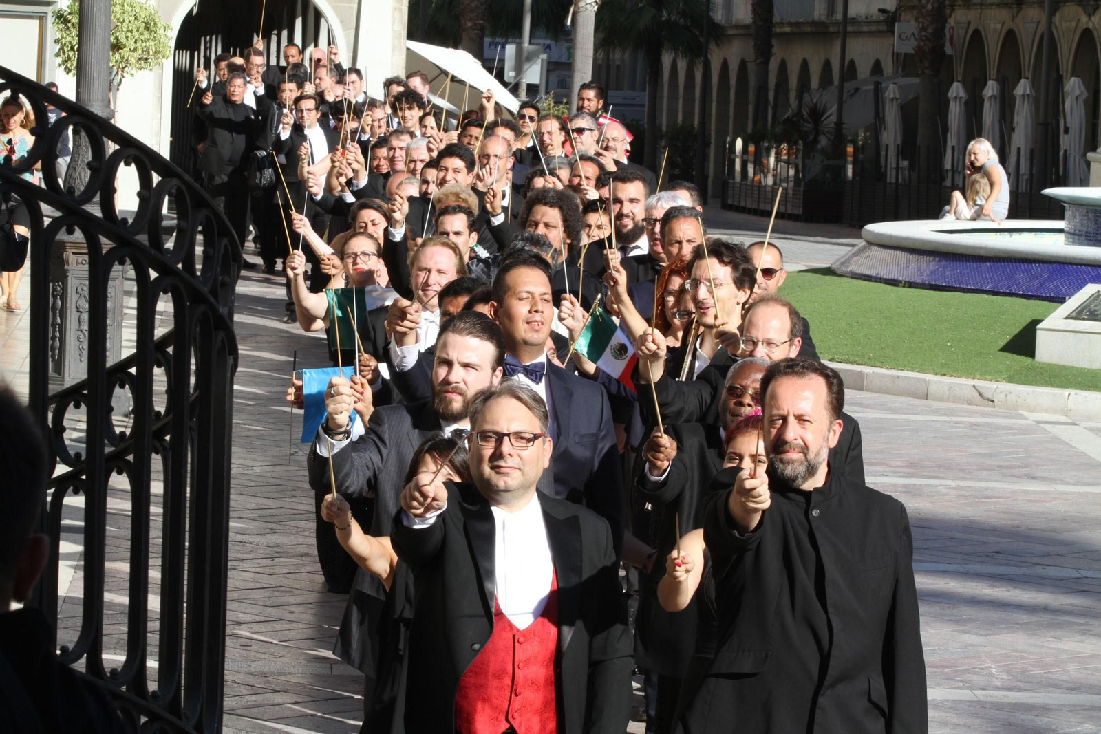 Los directores de orquesta, ayer por la tarde, con las batutas en alto entre la céntrica plaza de las Monjas y la Gran Vía de la capital onubense.