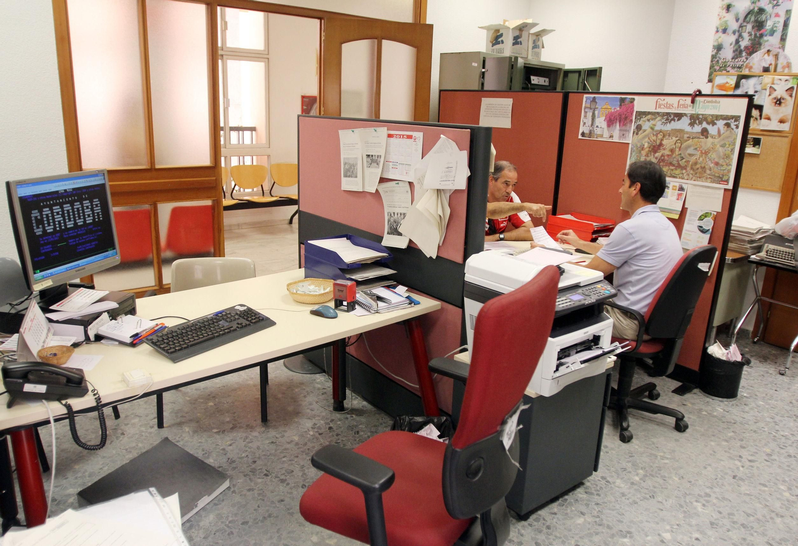 un funcionario atiende a un ciudadano en el Ayuntamiento.