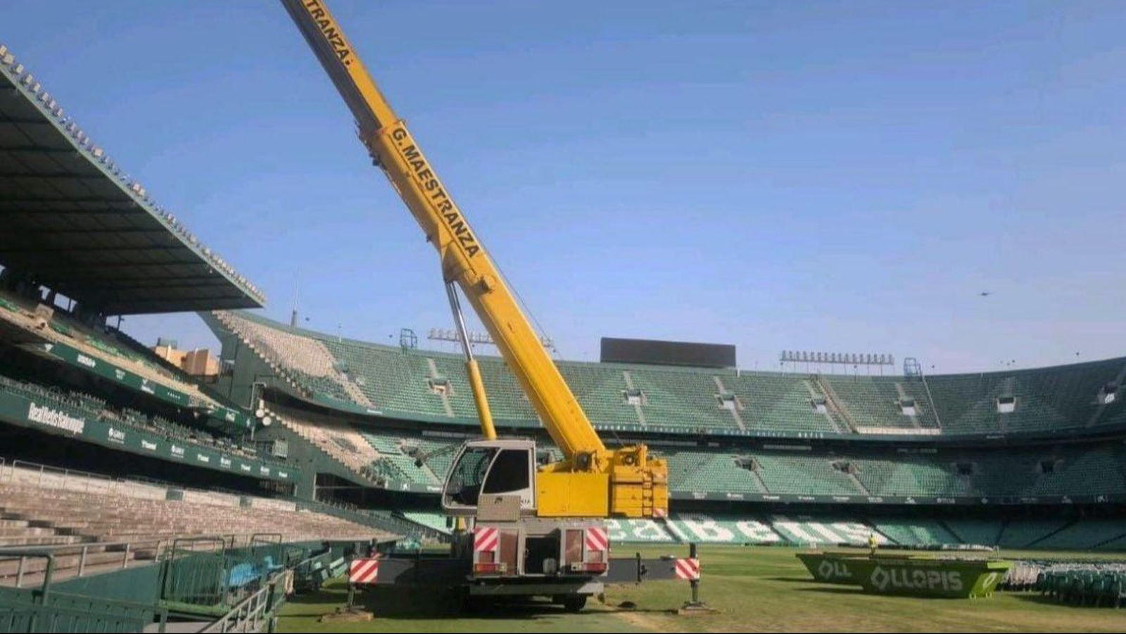 La máquina encargada de la demolición, ya en el césped del Villamarín. Y casi toda Preferencia, ya sin asientos.
