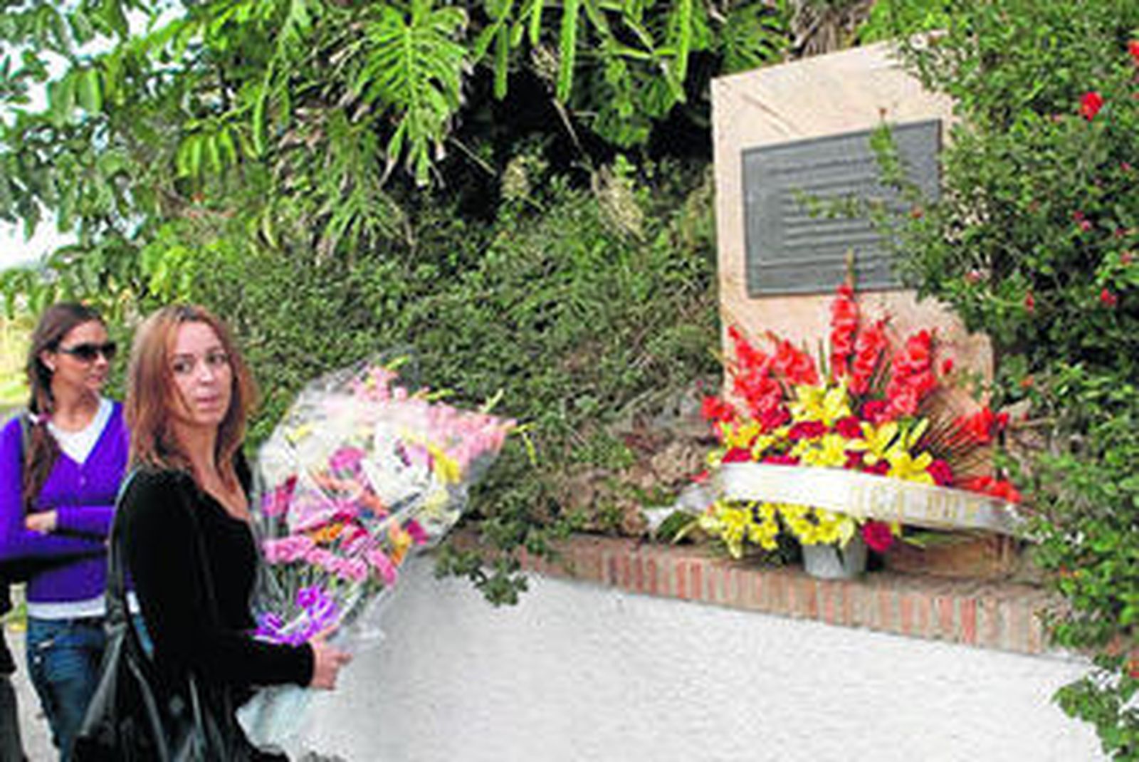 Una joven deposita un ramo de flores en memoria del suceso.