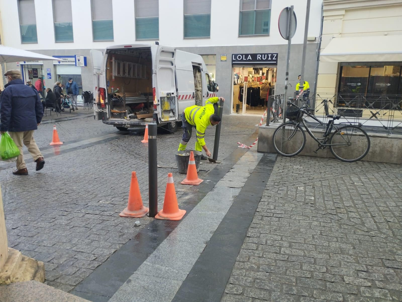 Operarios instalan ayer las pilonas en la calle Doña Blanca.
