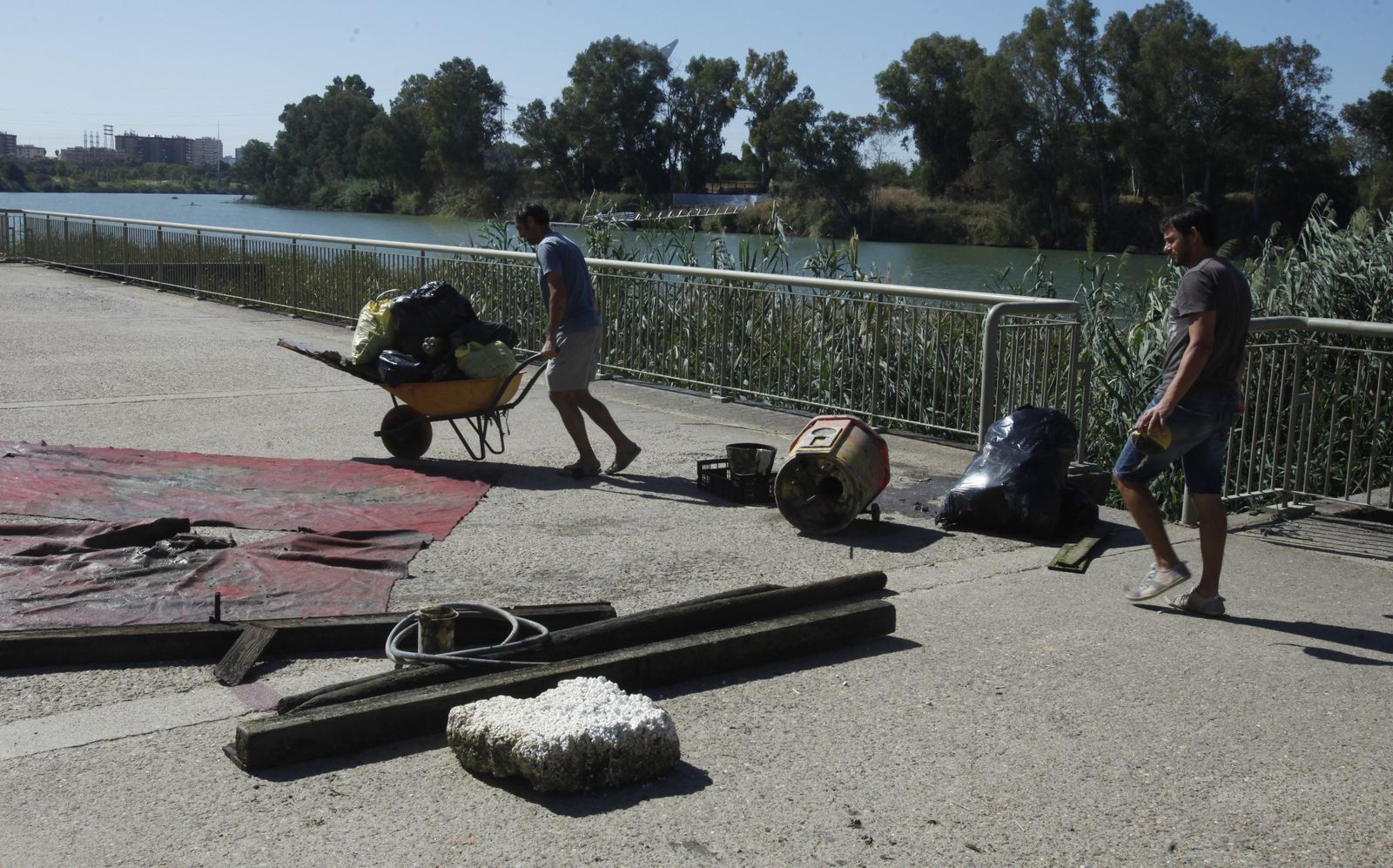 Uno de los ecologistas traslada parte de la basura aparecida en la dársena.