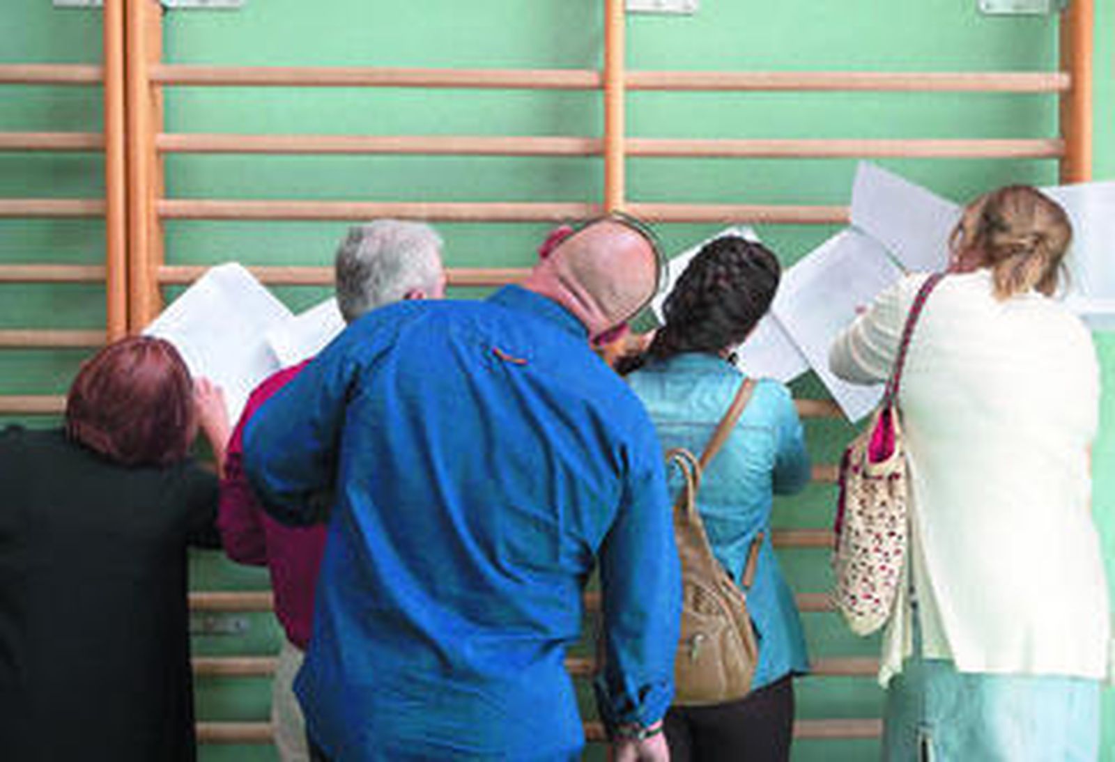 Varias personas consultando el censo electoral en un colegio antes de votar, el pasado domingo.