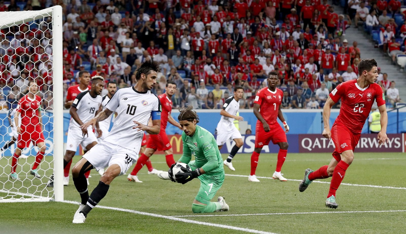 El meta suizo Sommer atrapa un balón junto al costarricense Bryan Ruiz.