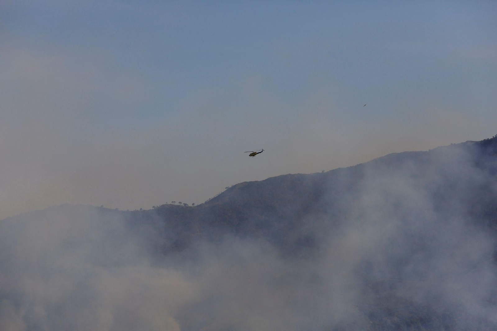 Un helicóptero sobrevuela la zona del incendio en Pujerra. Un helicóptero sobrevuela la zona del incendio en Pujerra.