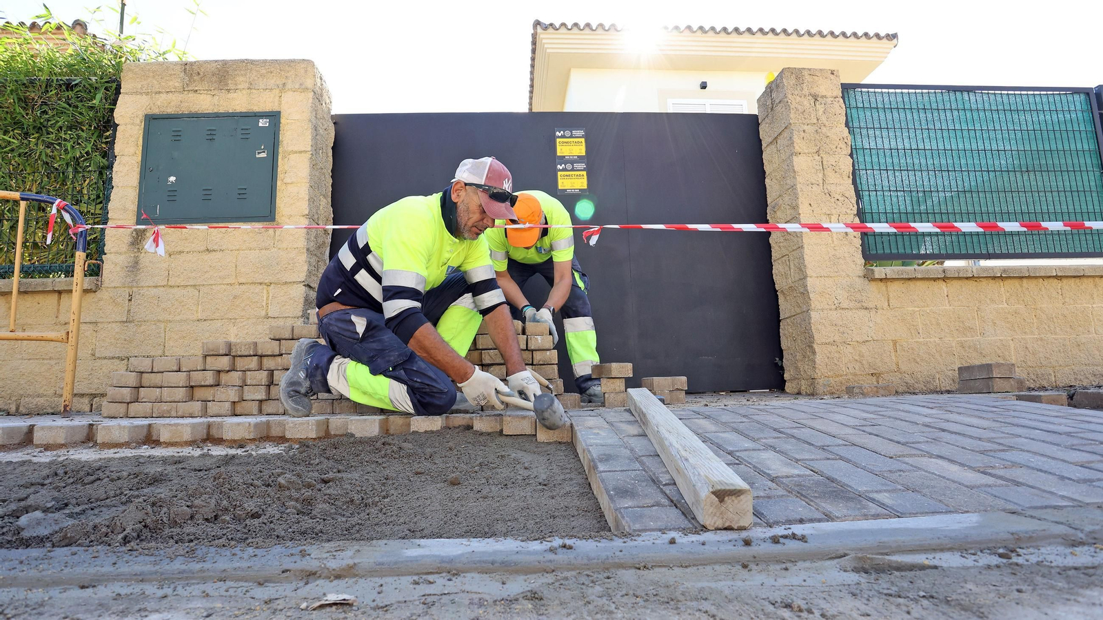 Dos trabajadores realizando trabajos de mejora en el acerado de calle Estrasburgo, esta misma semana.