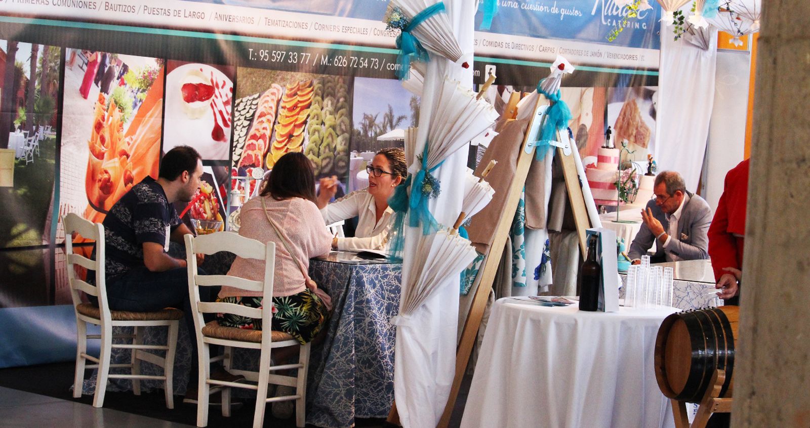 Uno de los expositores de la pasada edición de Bodasur atiende a una pareja de novios.