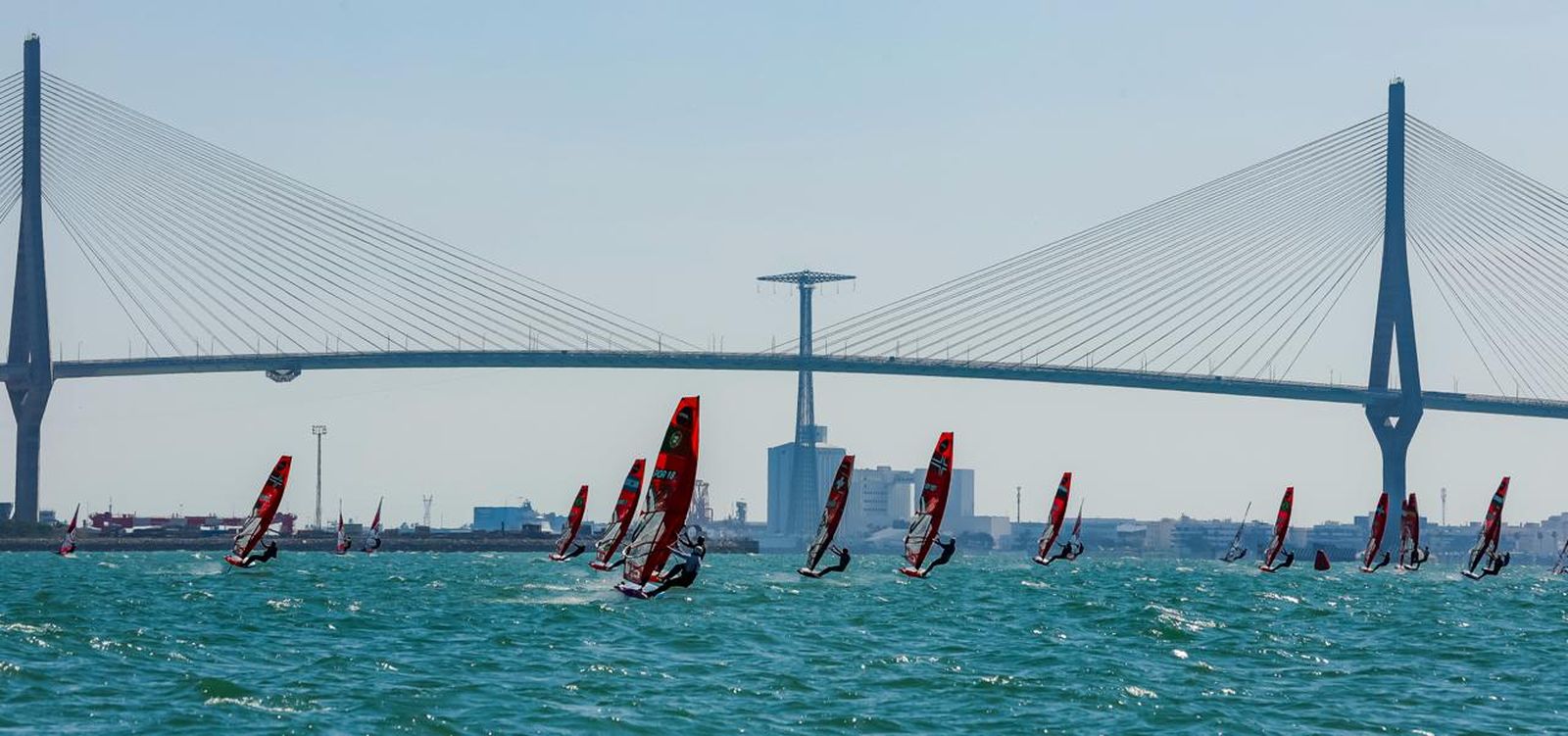 Una espectacular imagen con las iQFoil con el Puente de la Constitución de 1812 detrás.