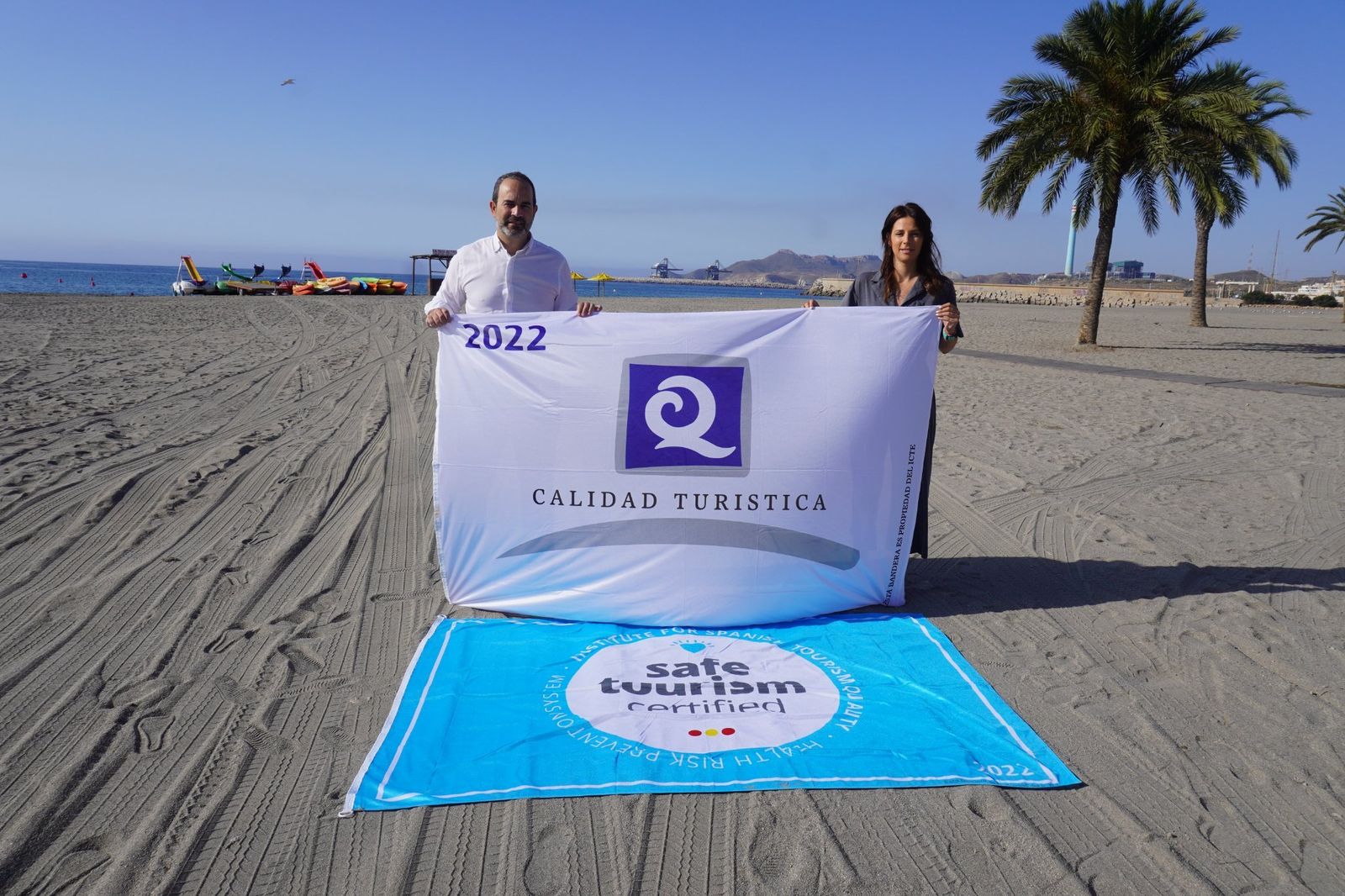 Alcalde y concejala de Playas muestran la bandera Q de Calidad Turística.