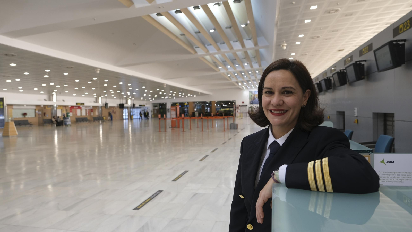 María Alicia posa sonriente en los mostradores de la terminal del aeropuerto de Almería