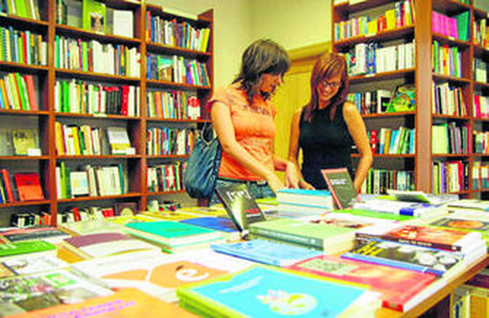 Varios clientes obervan la oferta que ofrece una librería de la ciudad.