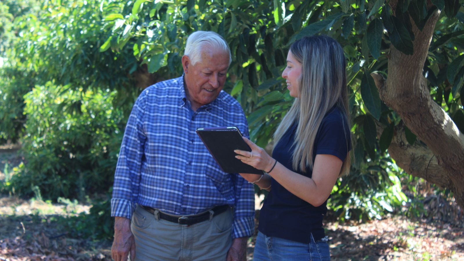 Una técnica de campo explica a un agricultor los resultados de la medición de agua.