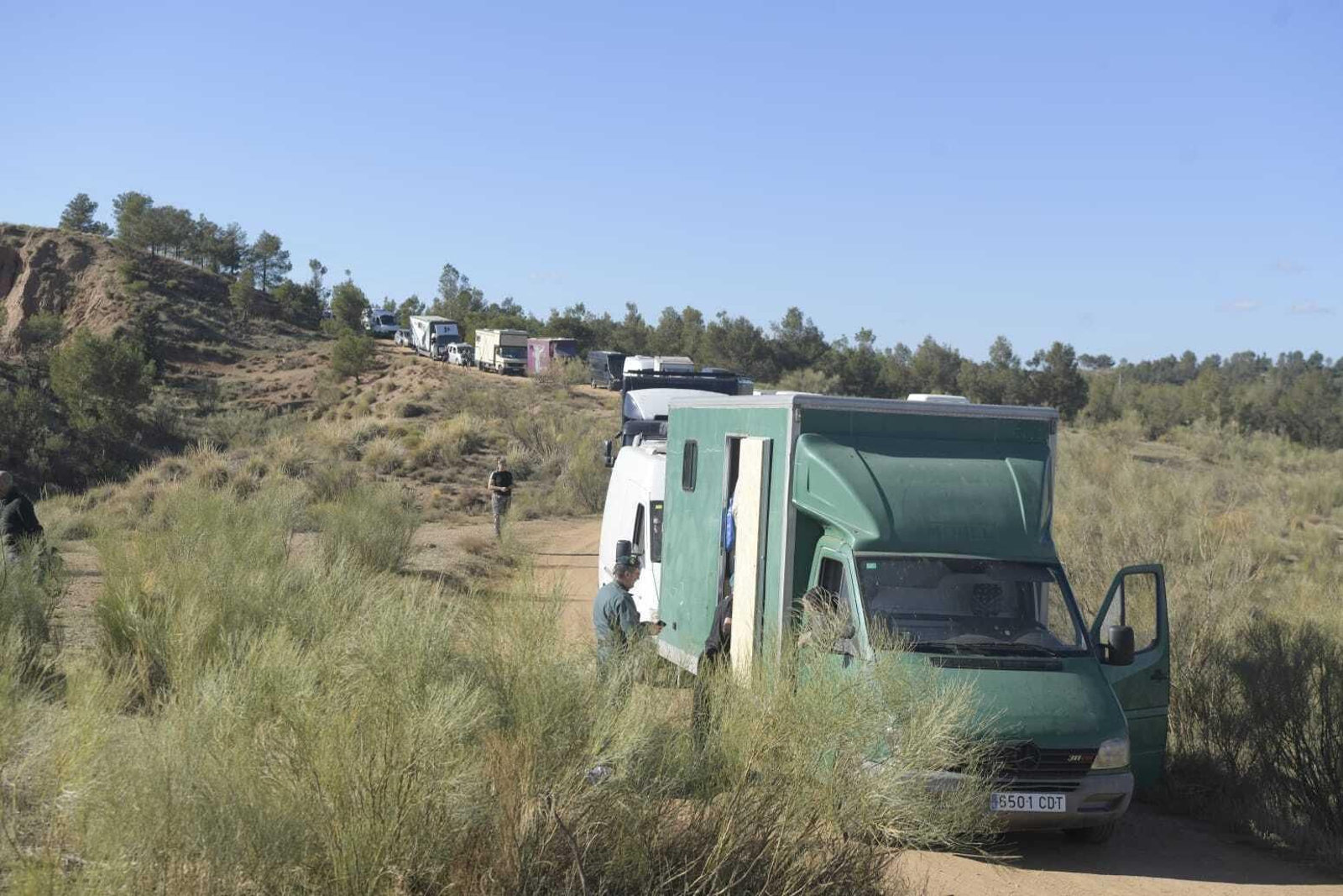 Un agente de la Guardia Civil, junto a una de las camionetas de la fiesta