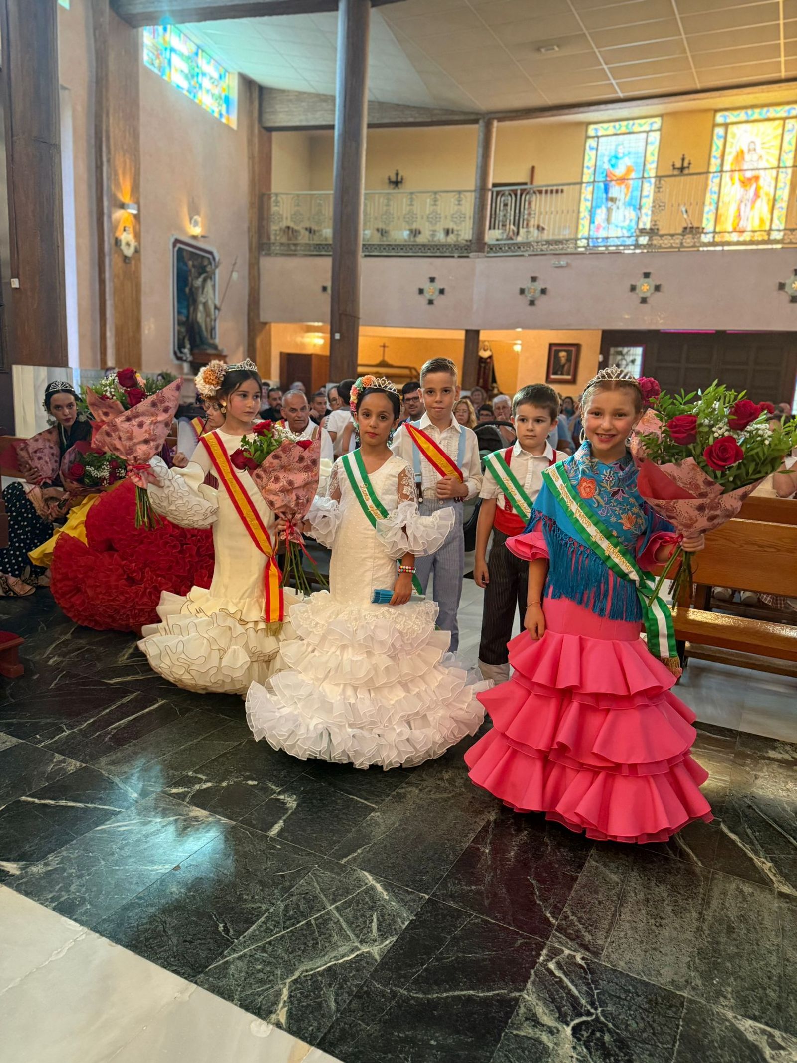 Los reyes y reinas de las fiestas en la ofrenda floral.