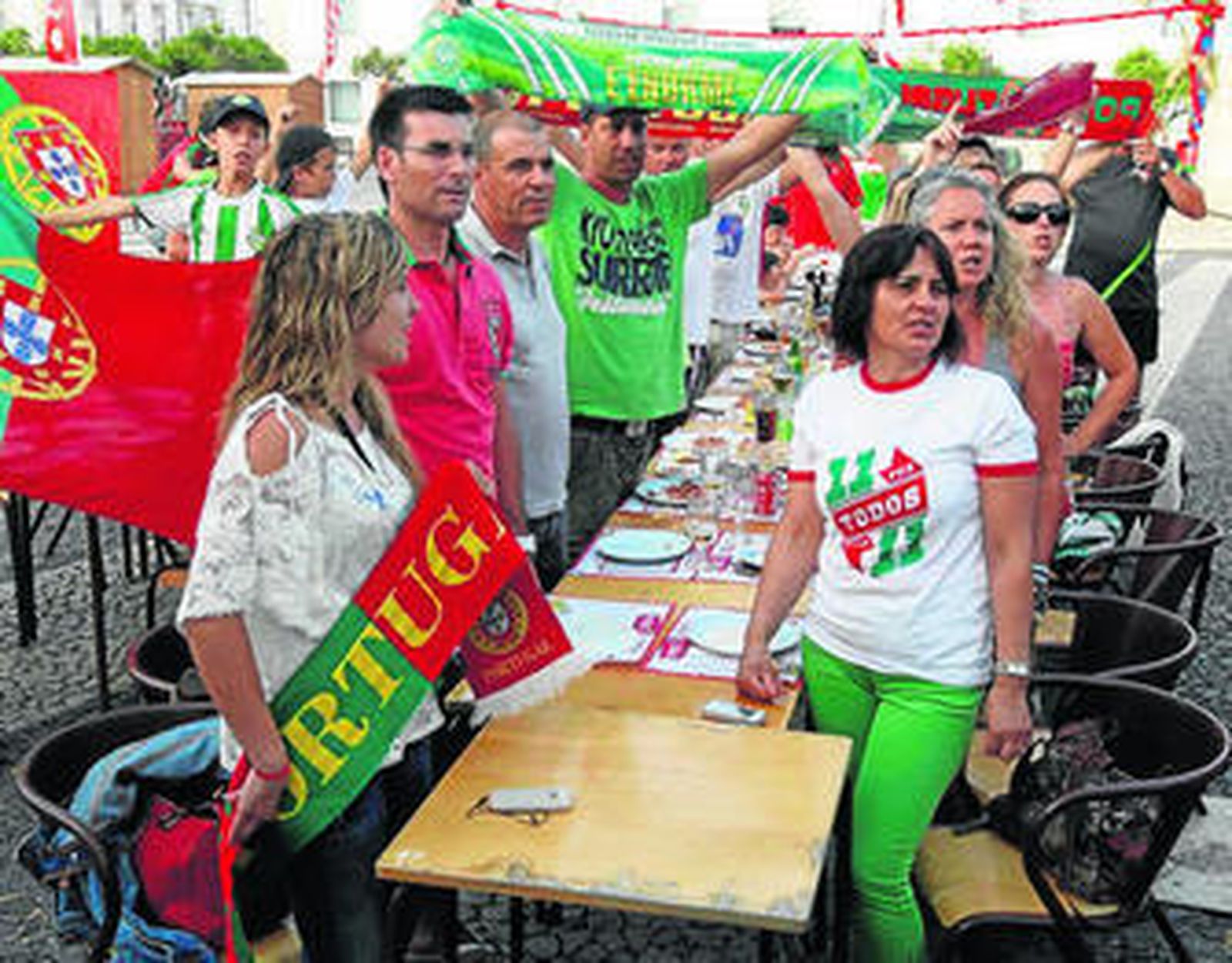 1. Un grupo de padres procedente de Setúbal, que se encuentra en Vila Real acompañando a sus hijos en un torneo de fútbol, animando a su selección. 2. La calle de La Moda en Ayamonte fue el lugar de encuentro de muchos seguidores españoles. 3. Una gran bandera de España hace  de toldo para los aficionados hispanos en el municipio onubense, donde se festejó por todo lo alto el triunfo de la Roja. 4. Dos seguidores portugueses, ataviados con los colores de su selección.