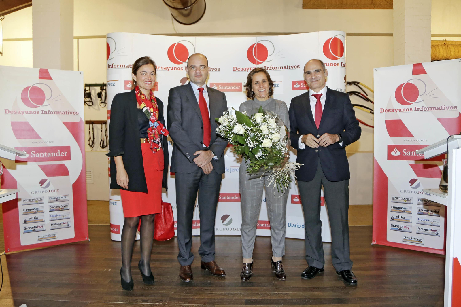 Julia Fernández Lizán, Justiniano Cortés y José Pedro Gómez García entregan un ramo de flores a Helena Rivero.
