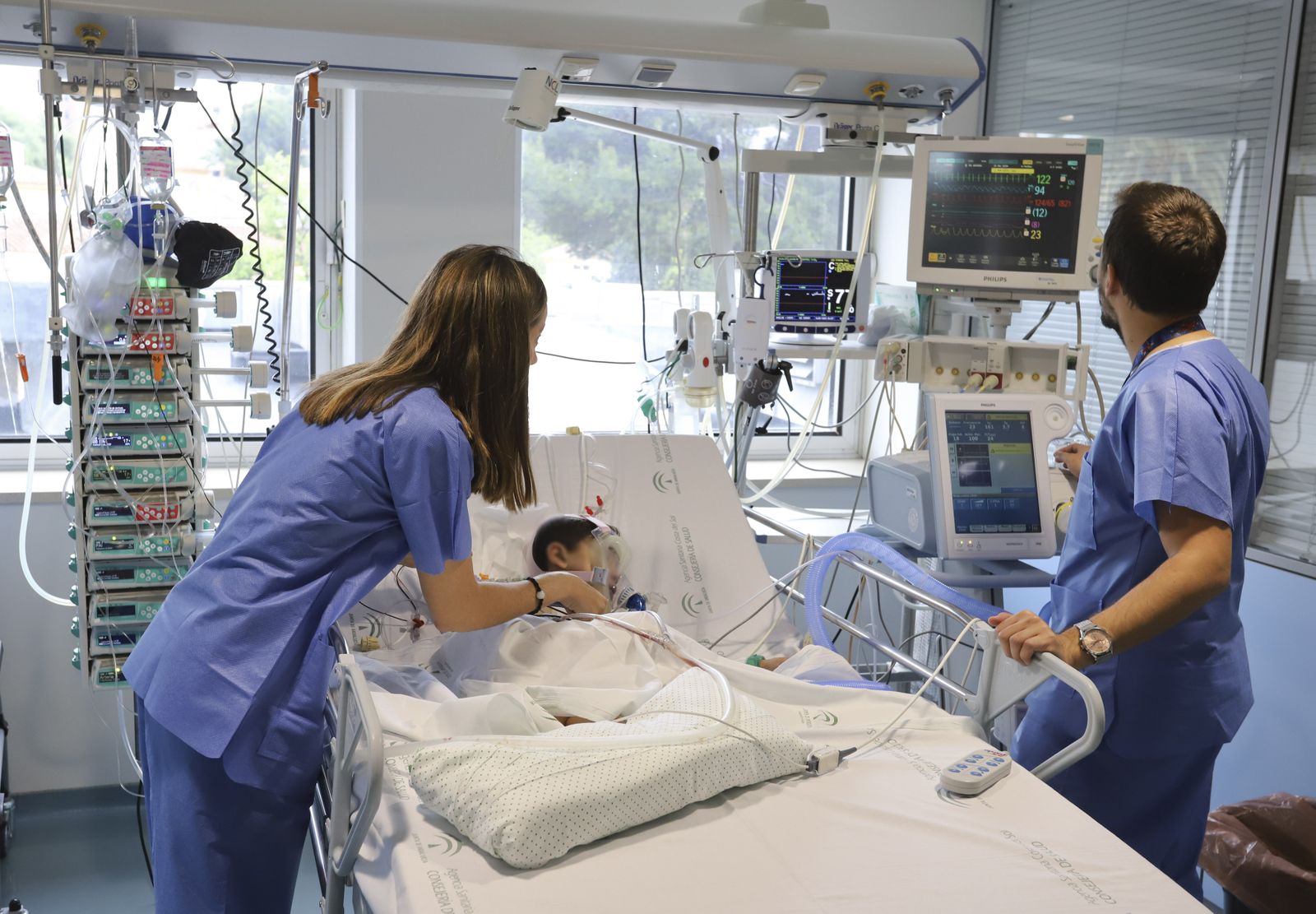 Dos enfermeros junto a un paciente en el área Infantil de un Hospital.