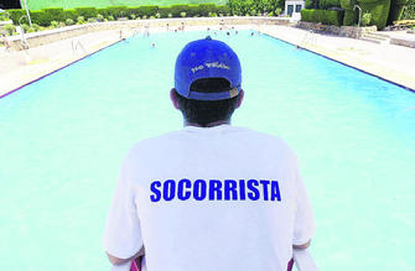 Un socorrista vigila la piscina mientras los niños se divierten.