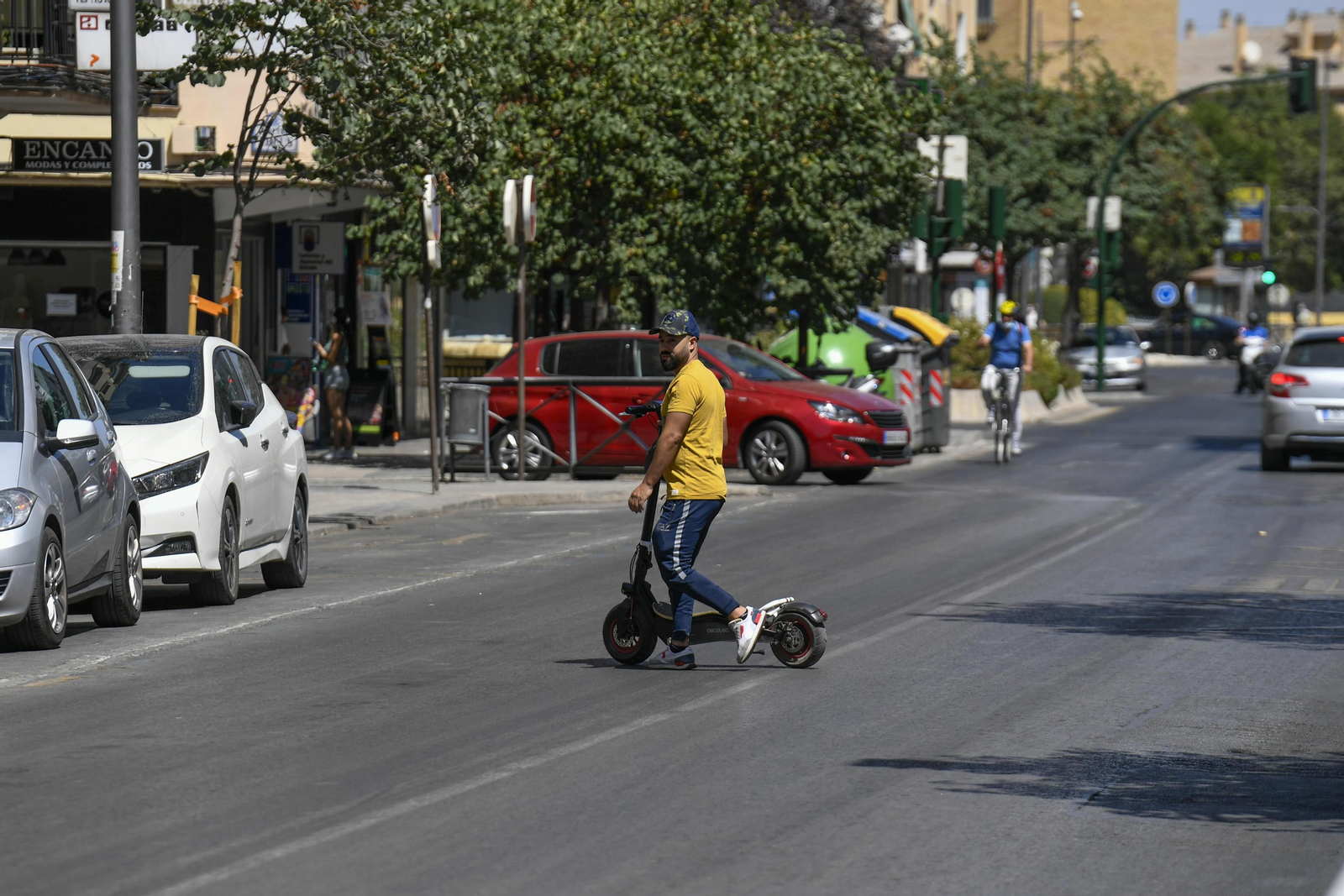 Un hombre cruza una calle de Granada con su patinete por una zona prohibida
