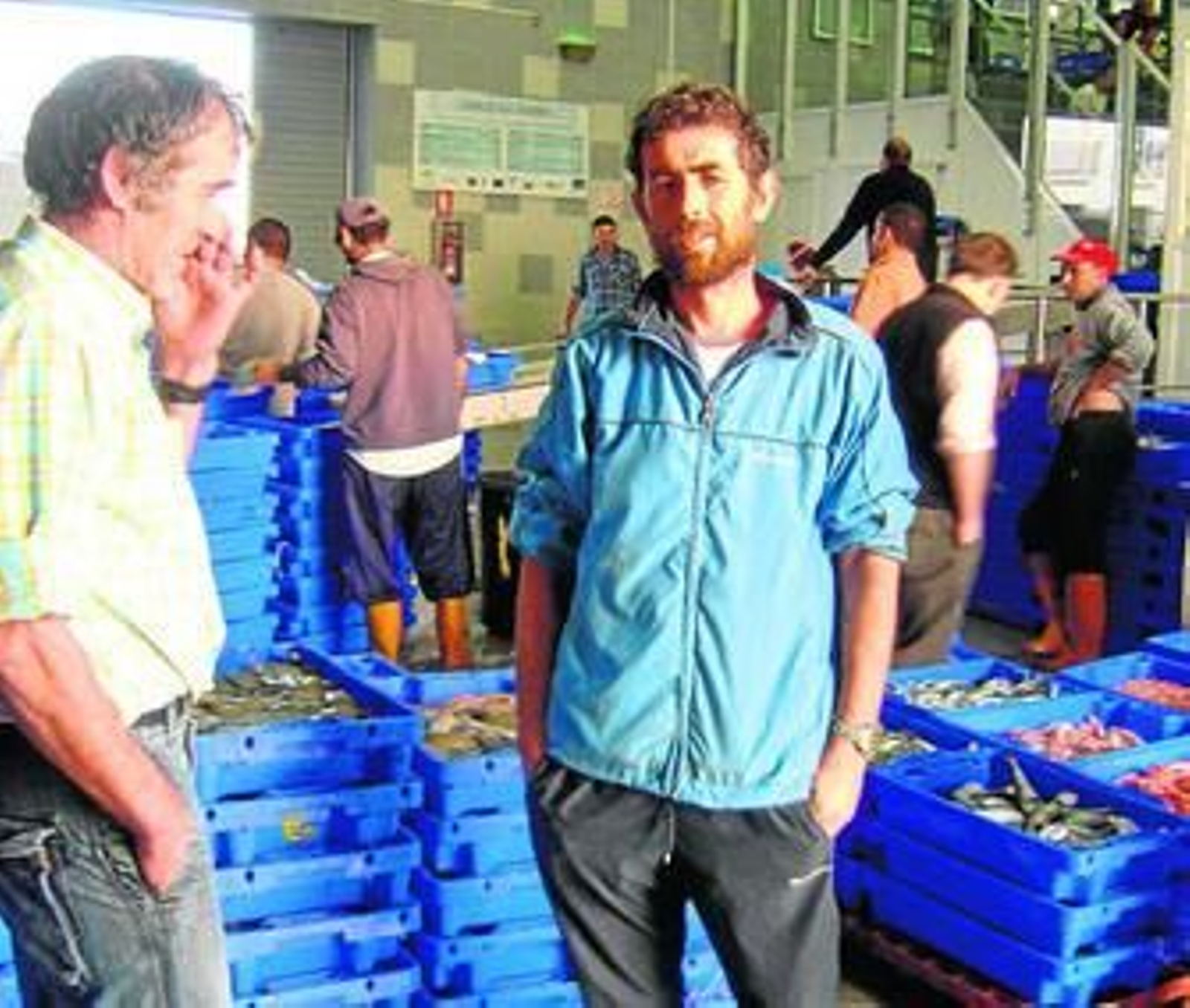 Un grupo de marineros, ayer tarde, en la lonja de Isla Cristina tras descargar las primeras capturas.