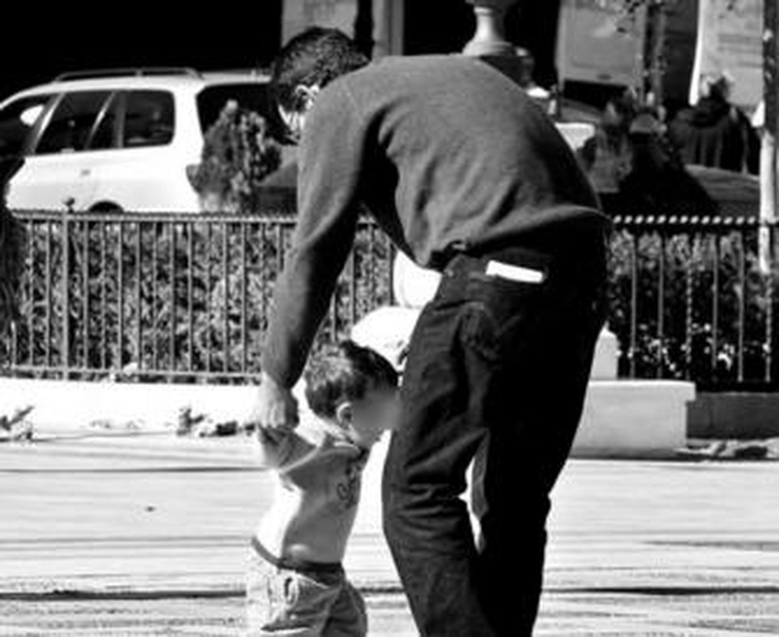 Un padre juega con su hijo en la calle.