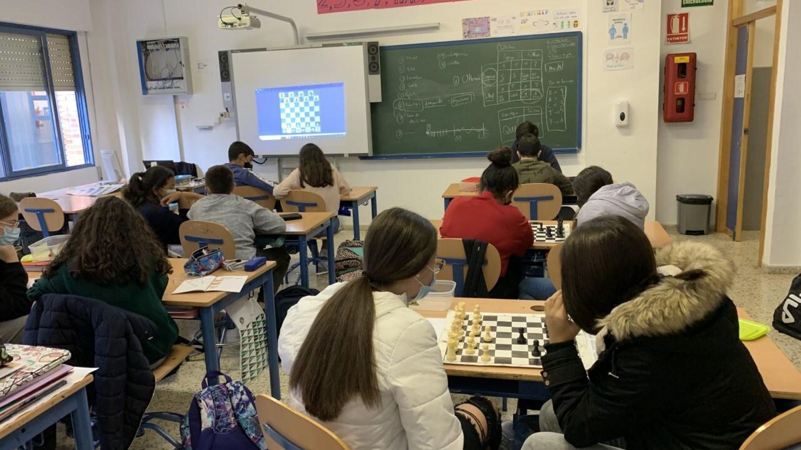 Los alumnos juegan una partida de ajedrez en el aula.