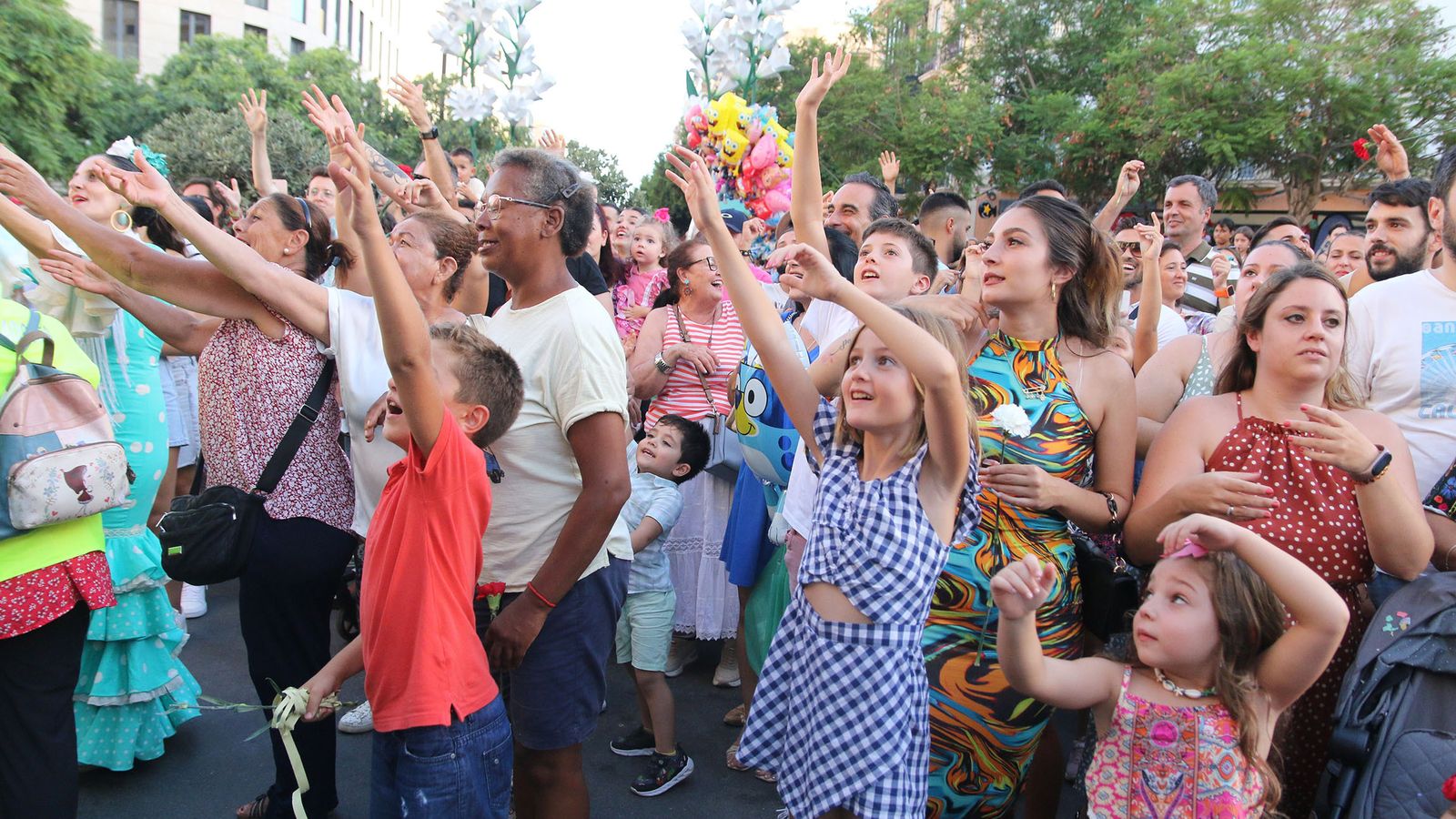 Los más pequeños aguardaron ansioso por agarrar algunos de los claveles arrojados desde las carrozas.