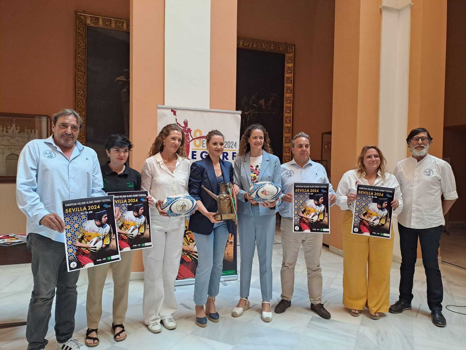 Los organizadores de el EGORF posan con el trofeo y el cartel que promociona el evento