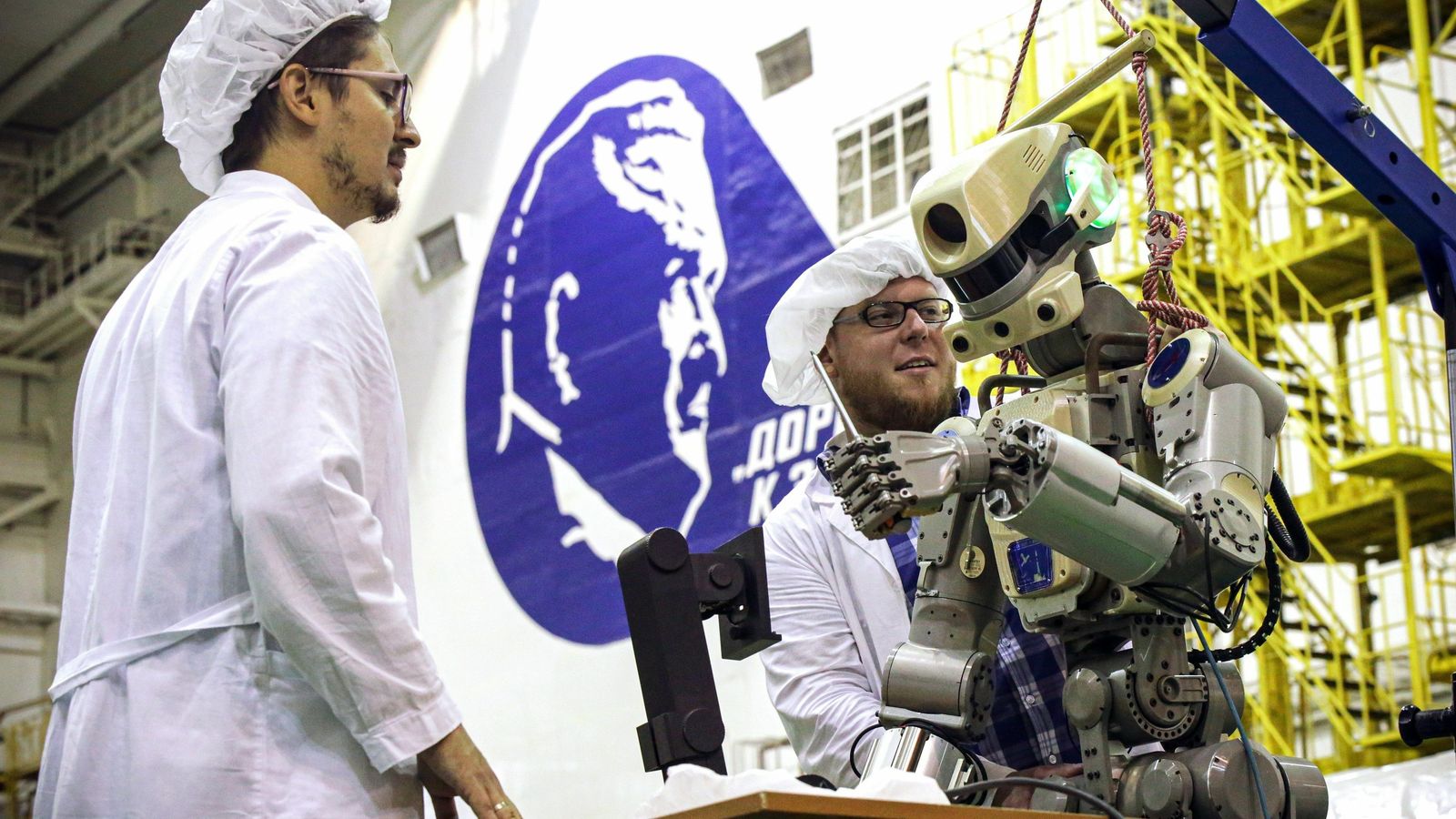 Varios operarios manipulan al androide.