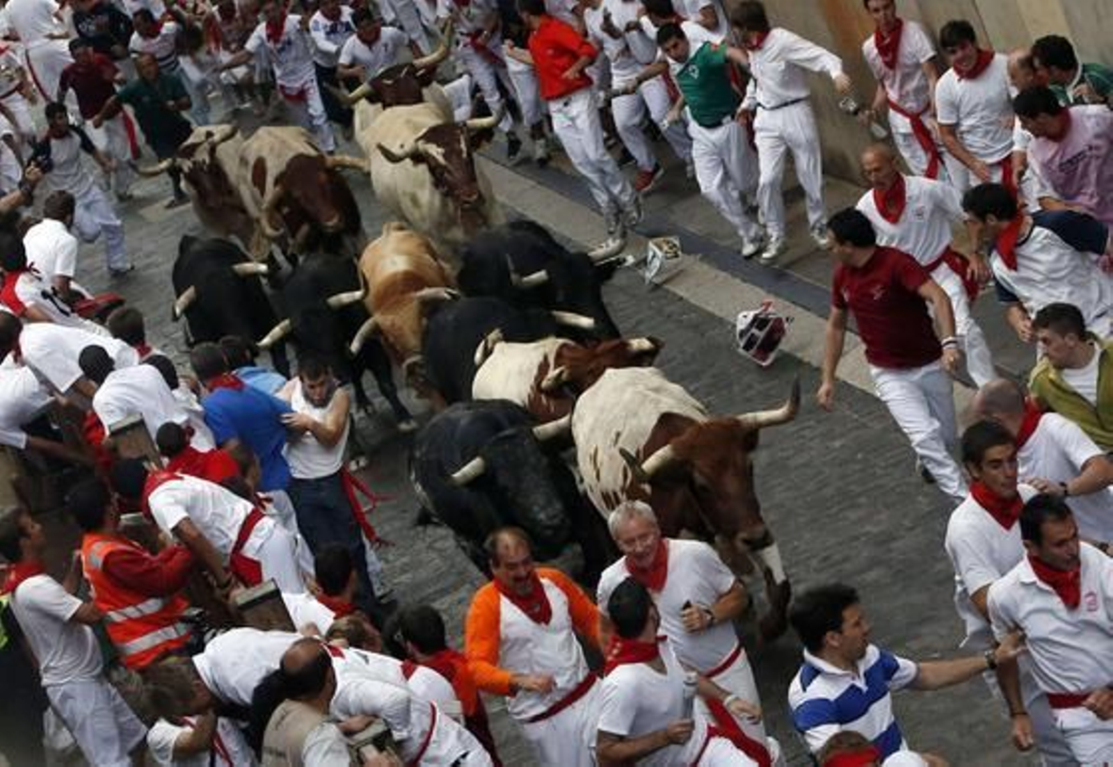 El primer encierro de 2012 finaliza con una cornada en el primer tramo y la entrada en la plaza de un toro con un mozo en una de sus astas.

Foto: EFE / Reuters