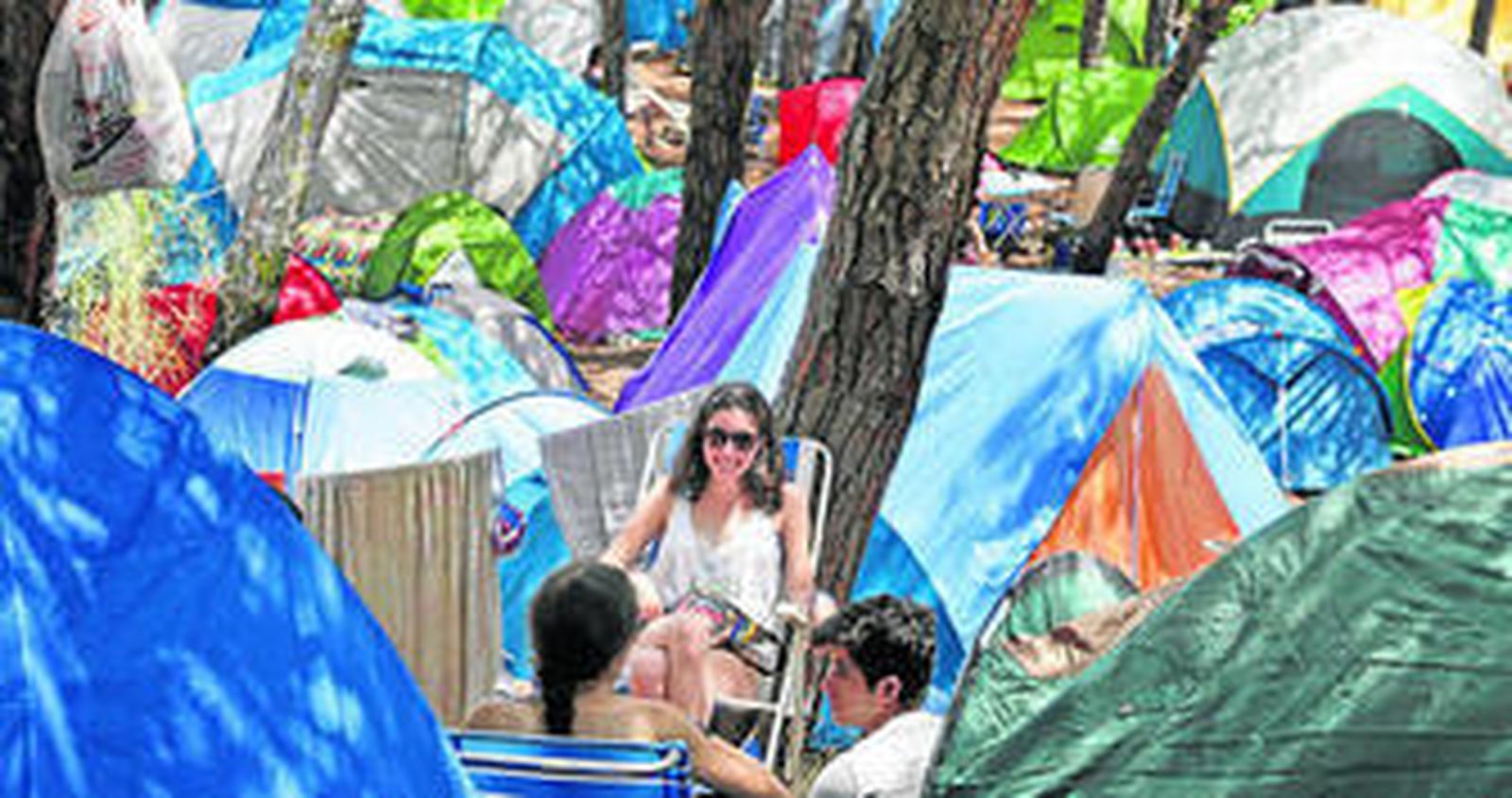 Un grupo de festivaleros en la zona de acampada más cercana al recinto de los conciertos, en medio de un pinar literalmente sembrado de tiendas.