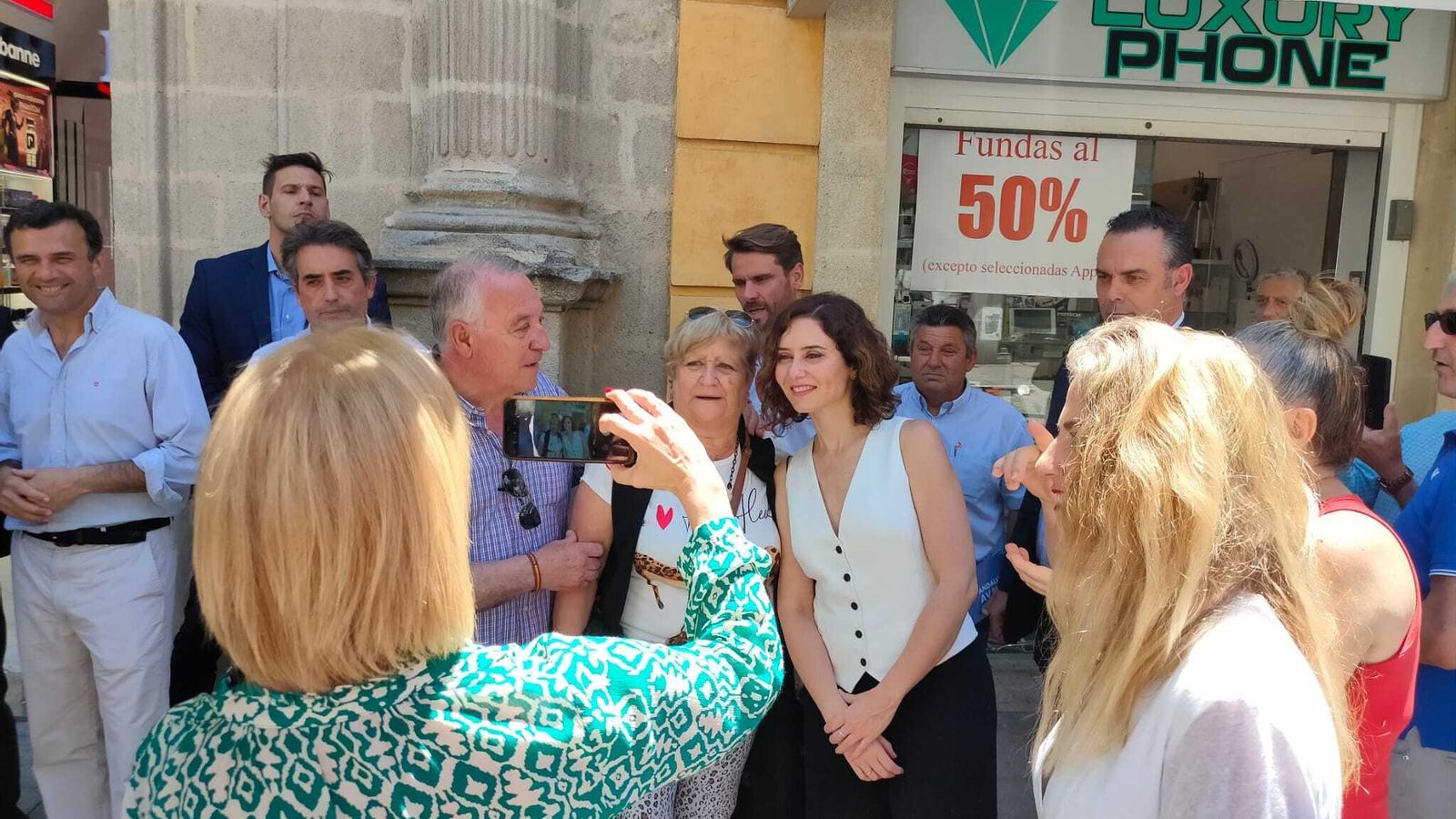 Pelayo hace una fotografía a una pareja junto a Ayuso.