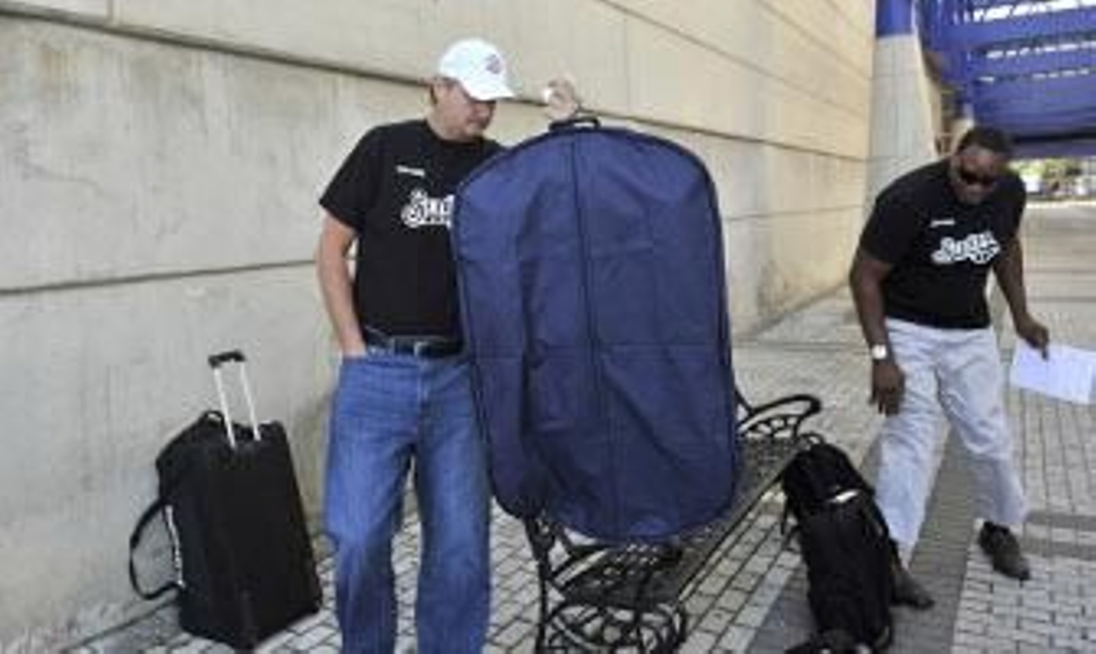 Roth y Norris, primer y segundo entrenador, respectivamente, del equipo hispalense, se disponen a colocar el equipaje en el autobús. / Juan Carlos Vázquez