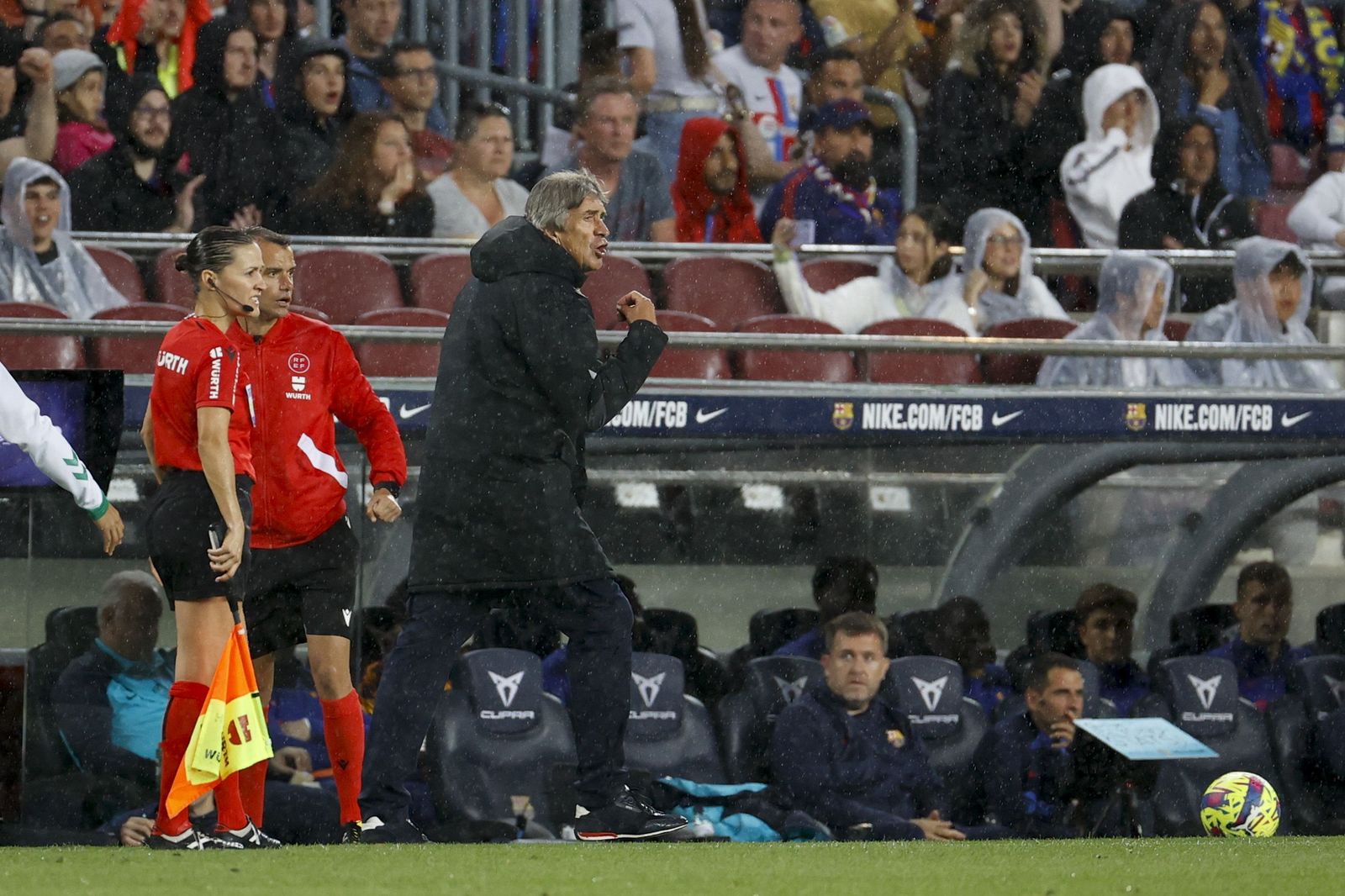 Pellegrini da instrucciones a sus jugadores bajo la lluvia en el Camp Nou.