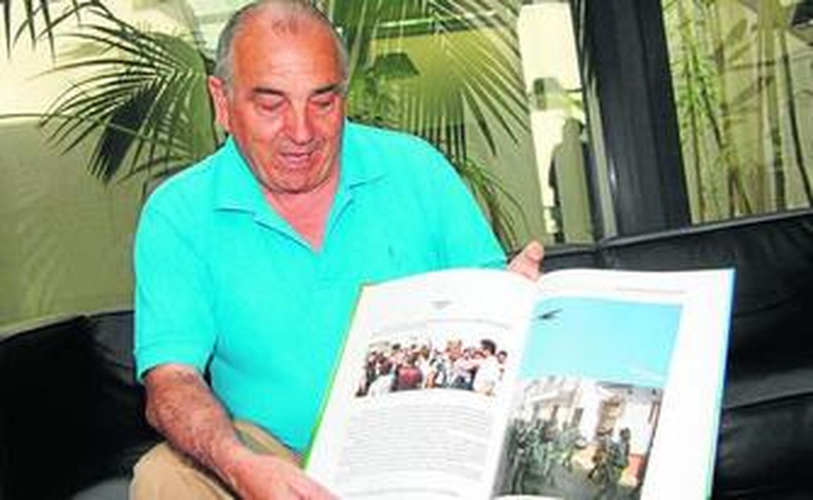 José Caro, con el libro del que es autor abierto por la página con la foto de la avioneta y la banda de la Legión.