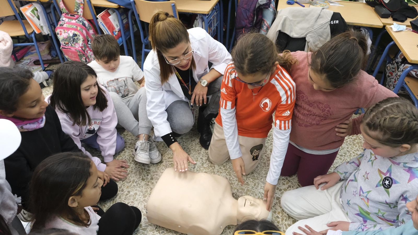 Los menores aprenden a realizar la maniobra RCP, a poner el cuerpo en posición lateral de seguridad y a aplicar la técnica frente-mentón para abrir las vías respiratorias a una persona inconsciente con maniquís del Hospital Universitario Torrecárdenas