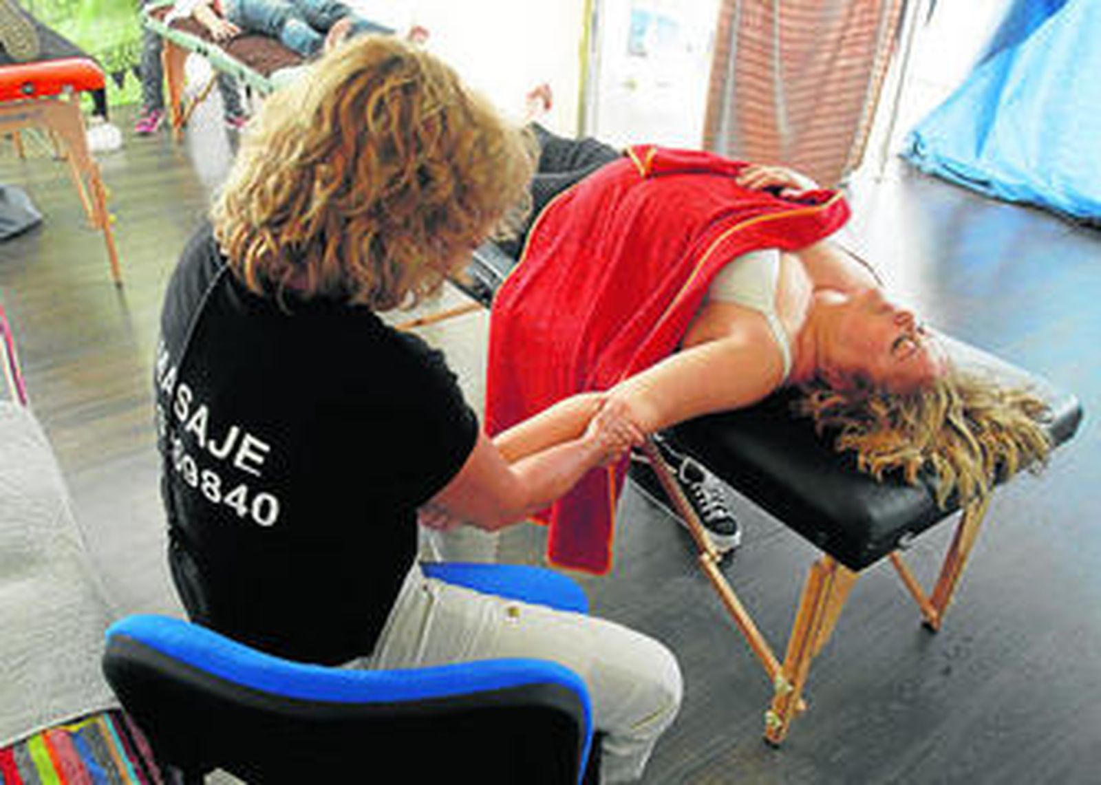 Una voluntaria da un masaje a una de sus pacientes, ayer durante el evento benéfico.