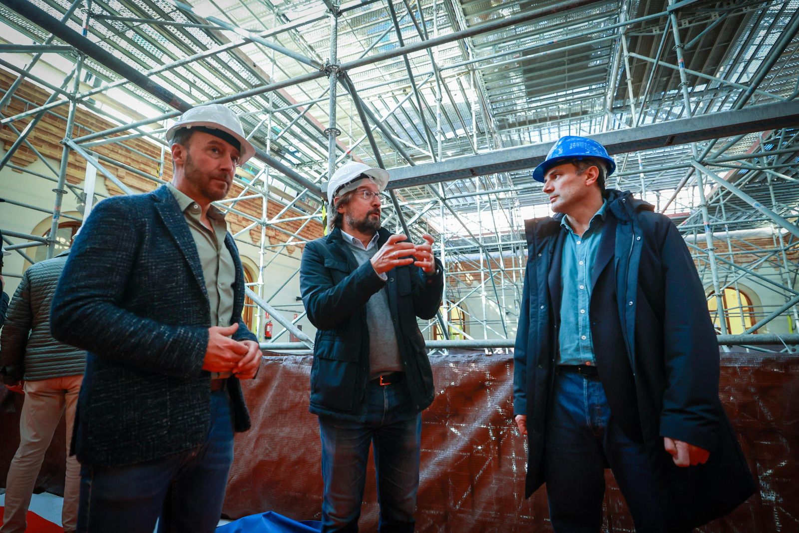 El arquitecto municipal Manuel Navarro, ante el andamiaje interior para la montera, explica detalles de la obra del Palacio de Congresos al alcalde Bruno García y el concejal José Manuel Cossi.