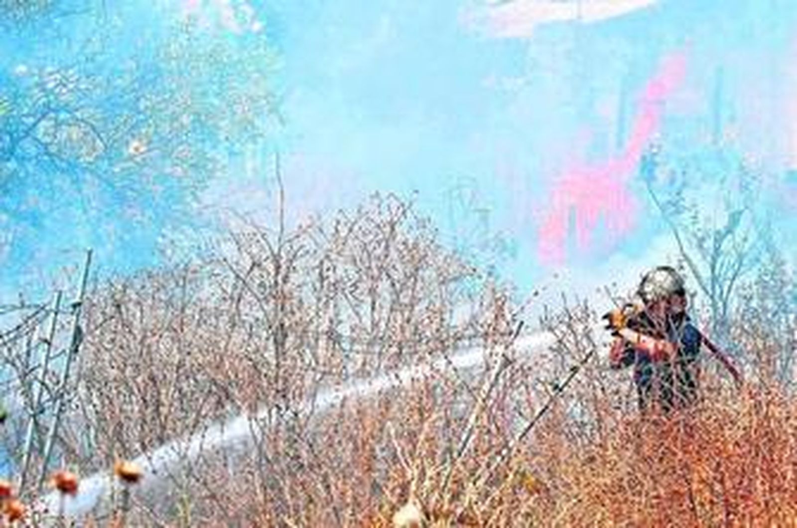 Un bombero apaga ayer el incendio surgido junto al asilo san José con ayuda de una manguera.