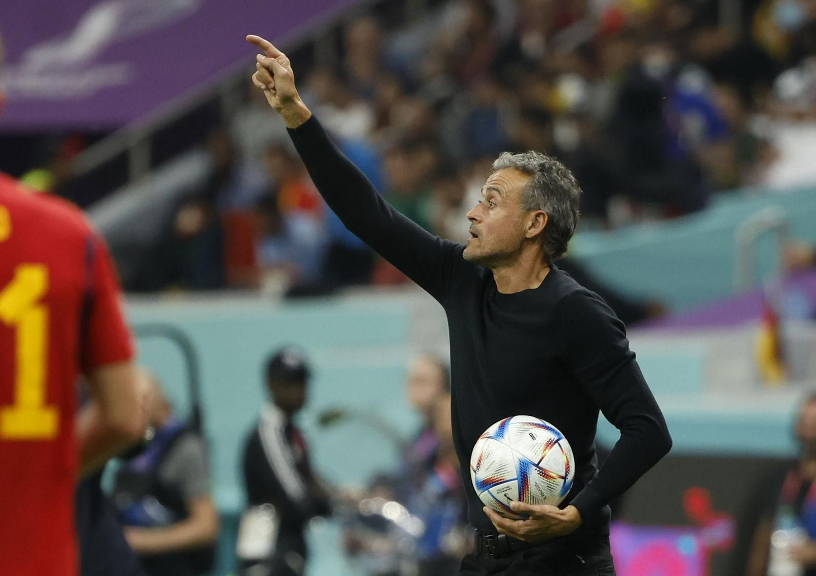 Luis Enrique da instrucciones desde el área técnica con un balón en la mano.